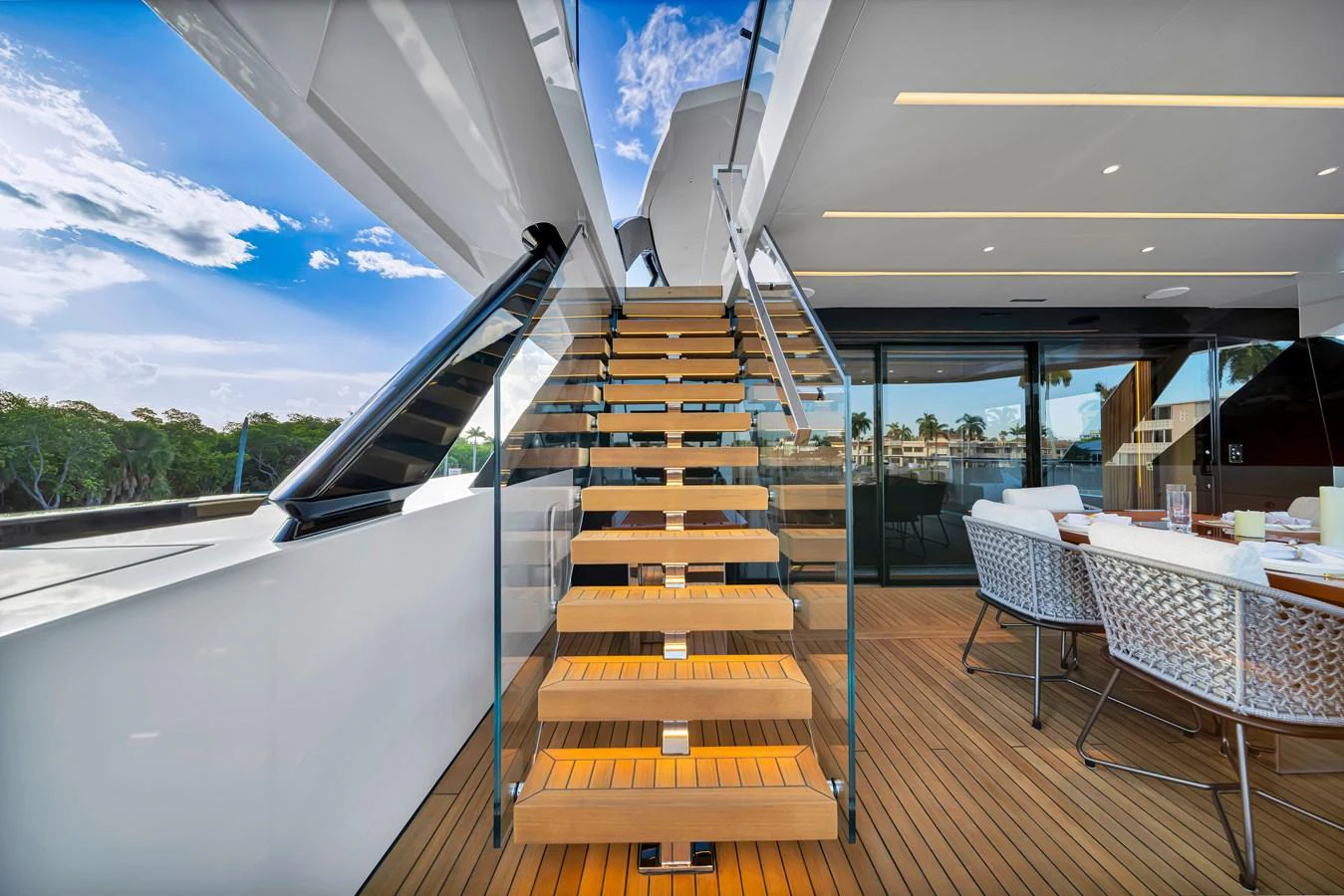 The aft deck features a stylish staircase leading to the upper deck, complemented by a sleek dining area. aboard BAGLIETTO DOM 133 #5 Yacht for Sale