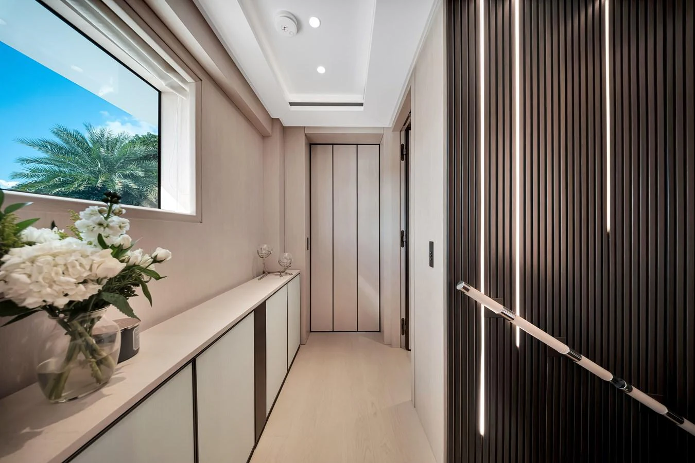 A sleek and modern hallway with elegant decor and a view of the outdoors. aboard BAGLIETTO DOM 133 #5 Yacht for Sale