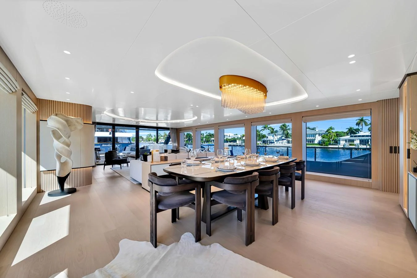 The yacht's dining area features elegant seating and a stunning chandelier, with large windows offering scenic views. aboard BAGLIETTO DOM 133 #5 Yacht for Sale