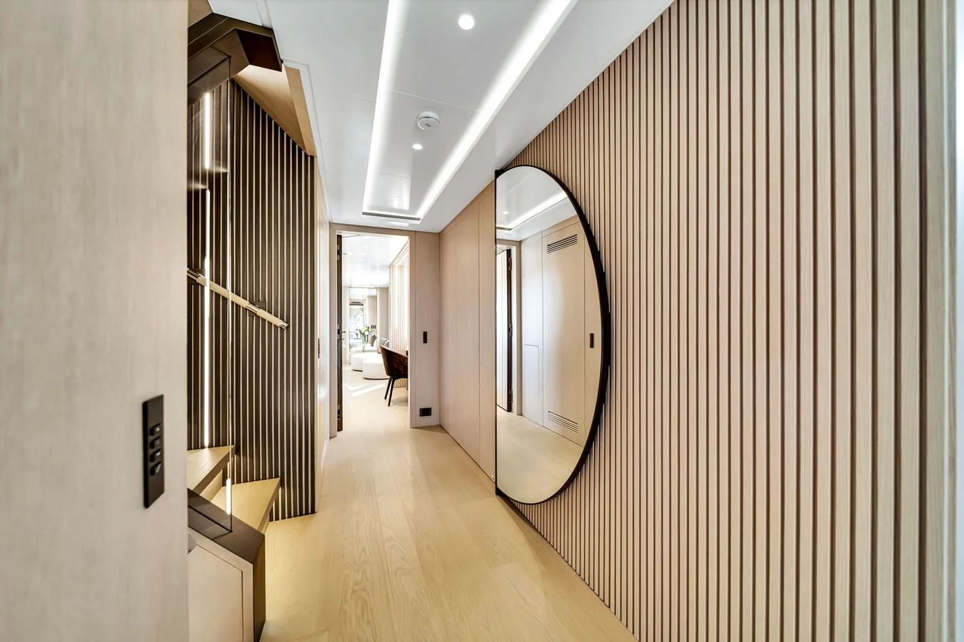 A stylish hallway with modern wood paneling and a large circular mirror. aboard BAGLIETTO DOM 133 #5 Yacht for Sale