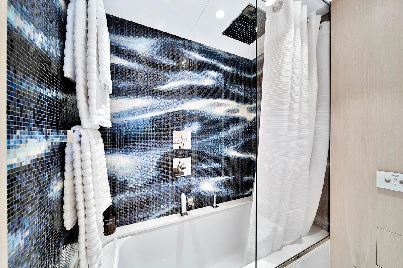 The yacht's bathroom features a modern design with a striking mosaic wall and luxurious fixtures. aboard BAGLIETTO DOM 133 #5 Yacht for Sale