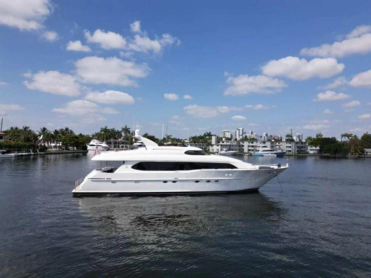 A sleek white yacht is gracefully anchored on calm waters under a clear blue sky. aboard TRANQUILITY IV - 94 FT LAZZARA MOTORYACHT 2001 Yacht for Sale