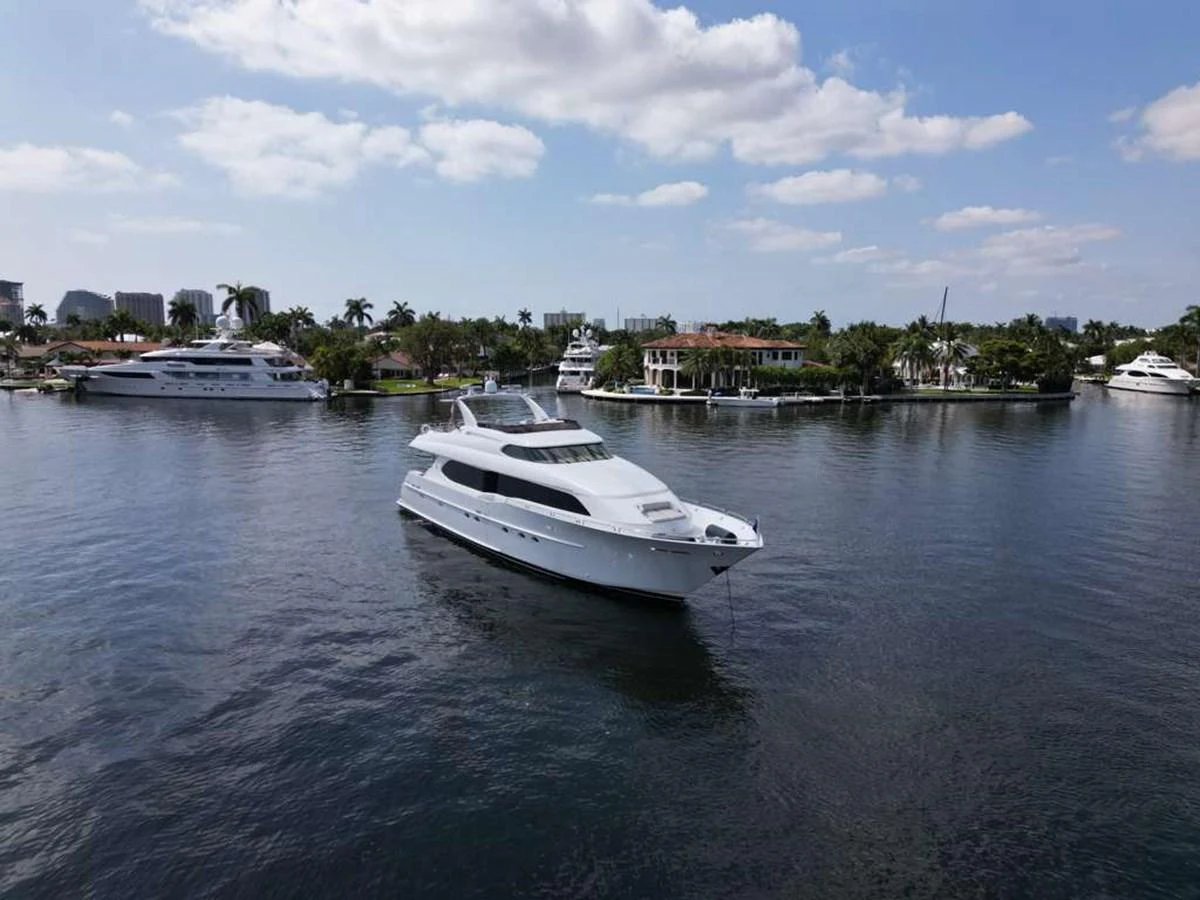 A sleek white yacht cruises gracefully on calm waters under a partly cloudy sky. aboard TRANQUILITY IV - 94 FT LAZZARA MOTORYACHT 2001 Yacht for Sale