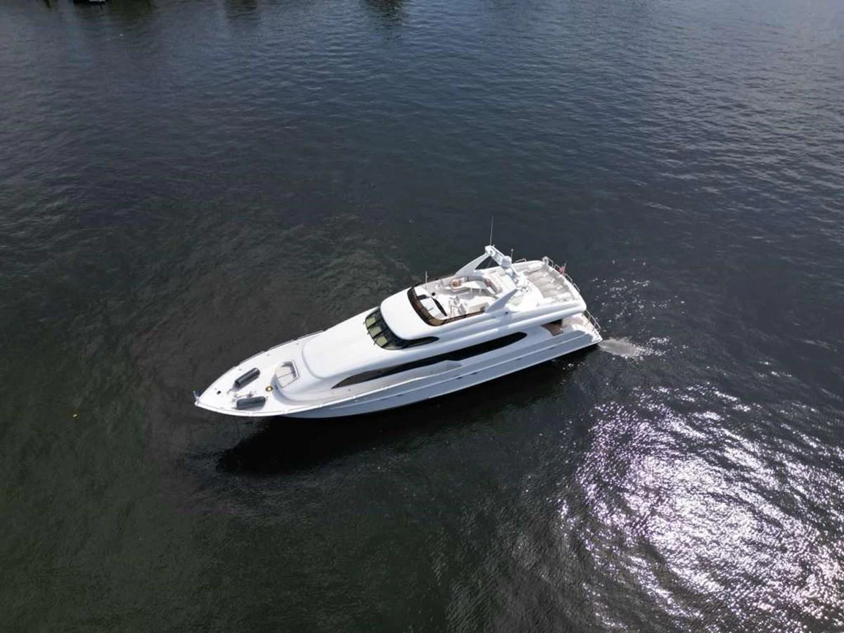 A sleek white yacht glides gracefully across calm waters, showcasing its elegant design. aboard TRANQUILITY IV - 94 FT LAZZARA MOTORYACHT 2001 Yacht for Sale