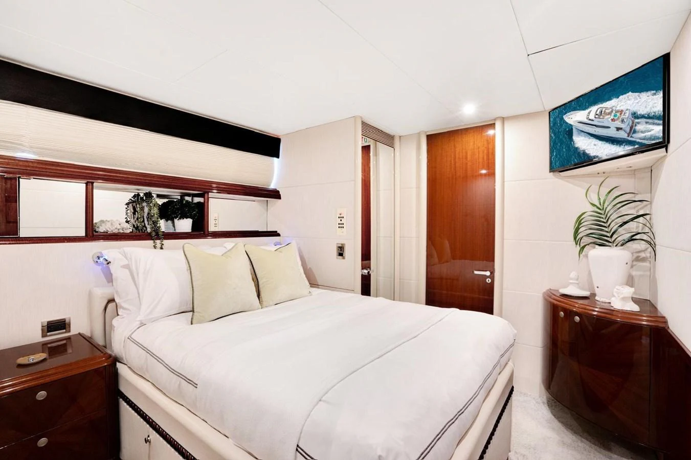 A luxurious stateroom featuring a plush bed, elegant wood finishes, and modern amenities. aboard TRANQUILITY IV - 94 FT LAZZARA MOTORYACHT 2001 Yacht for Sale
