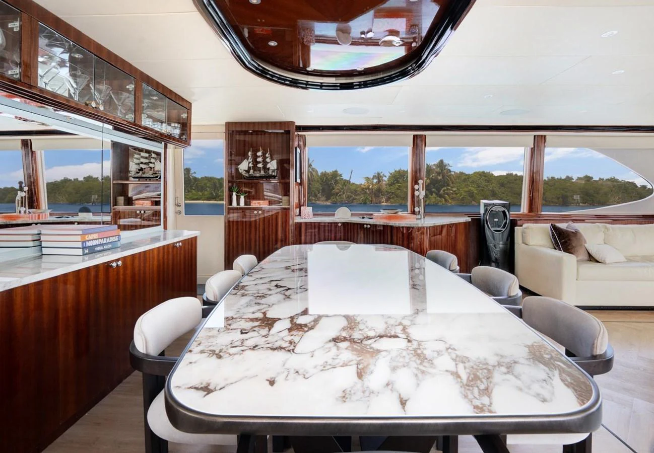 The yacht's dining area features a luxurious marble table and elegant wood finishes, offering a sophisticated setting for meals. aboard TRANQUILITY IV - 94 FT LAZZARA MOTORYACHT 2001 Yacht for Sale
