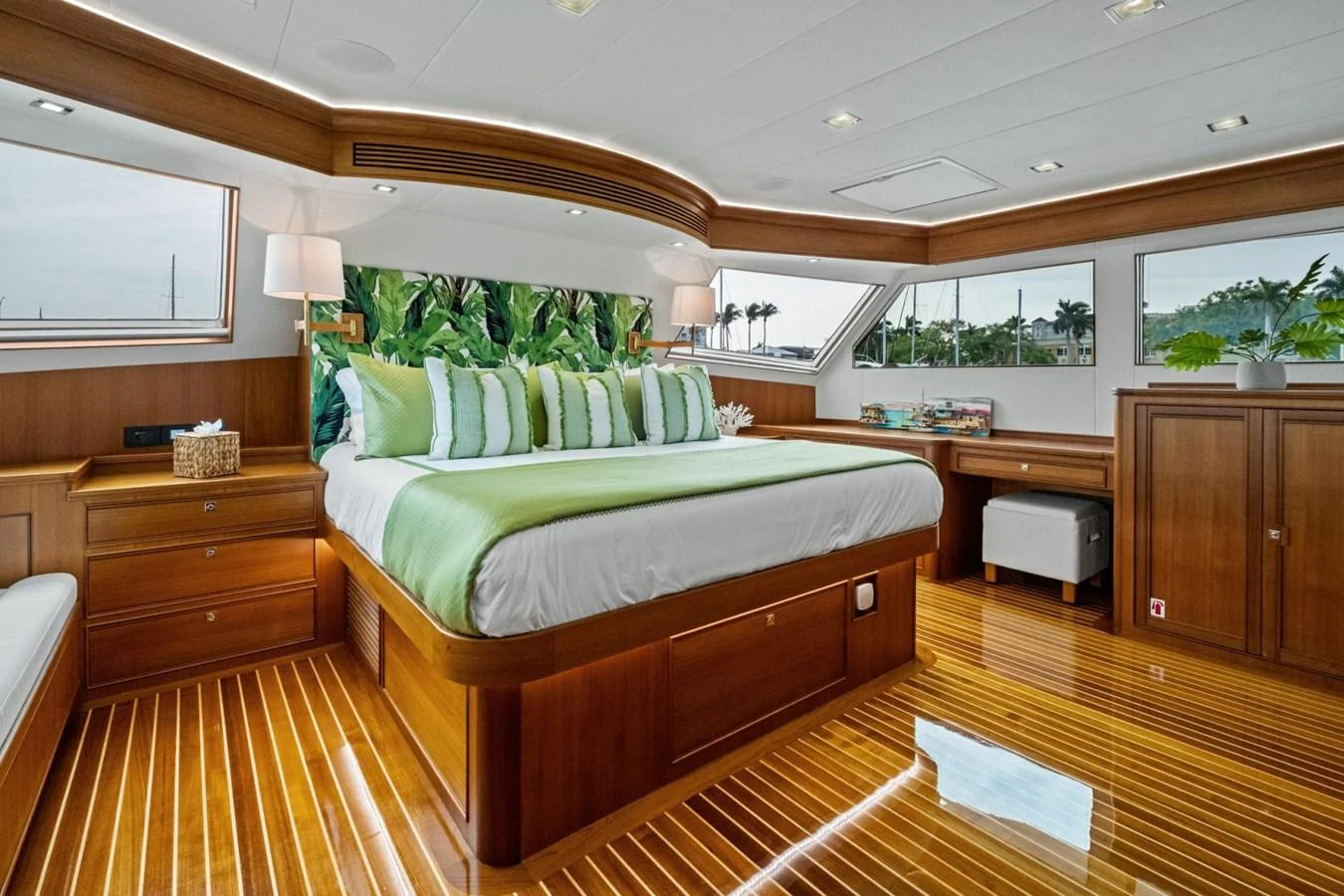 The master stateroom features a luxurious bed with vibrant green accents and ample natural light. aboard ARTEMIS II Yacht for Sale