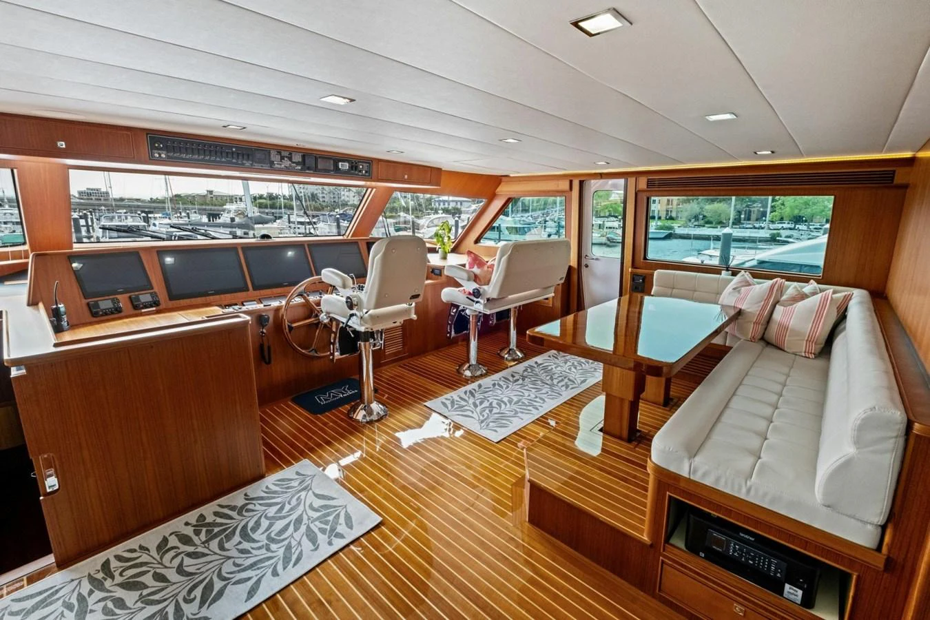 The helm area features luxurious seating, a wooden steering wheel, and expansive windows offering panoramic views. aboard ARTEMIS II Yacht for Sale