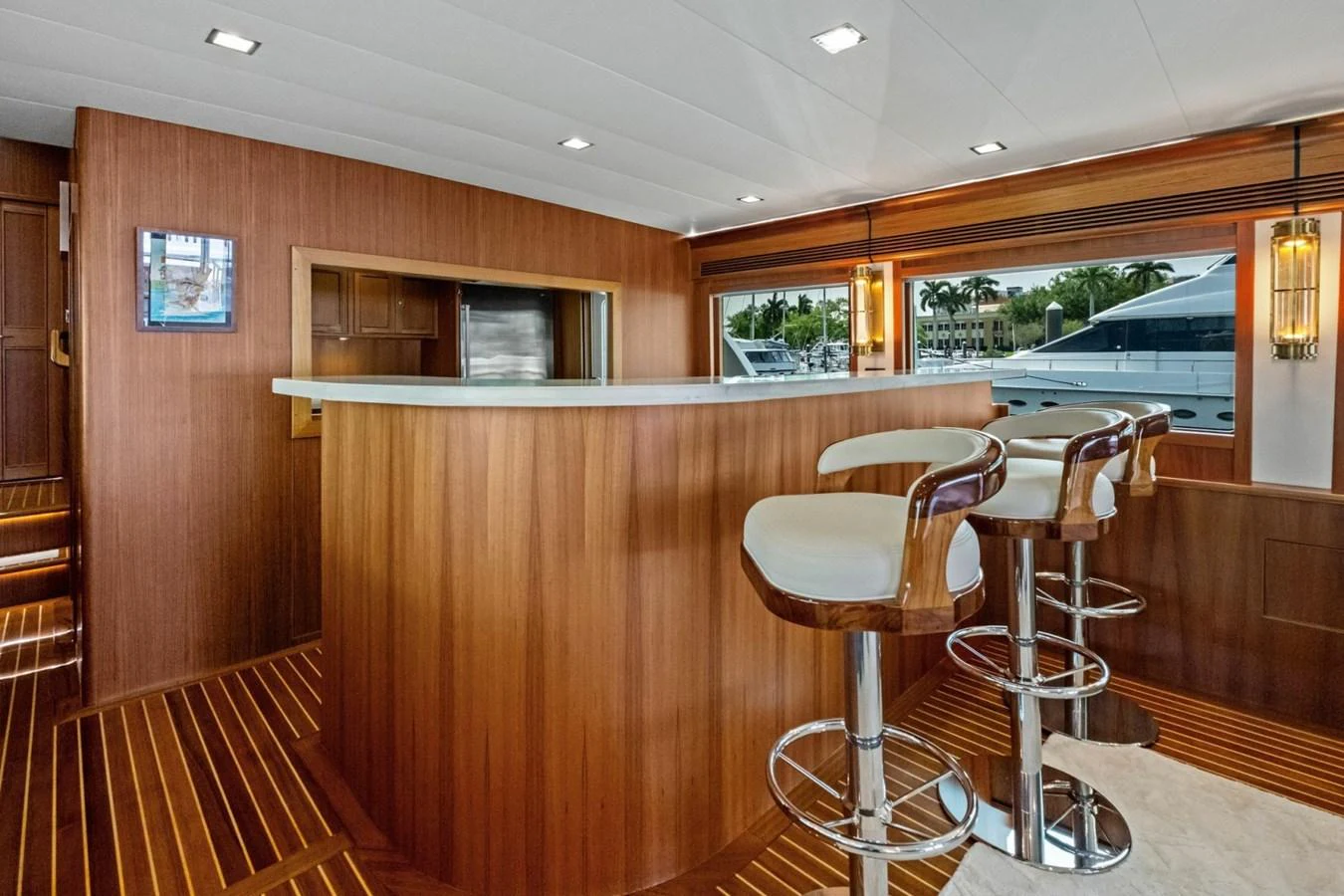 The yacht's interior features a stylish bar area with modern stools and warm wood finishes. aboard ARTEMIS II Yacht for Sale