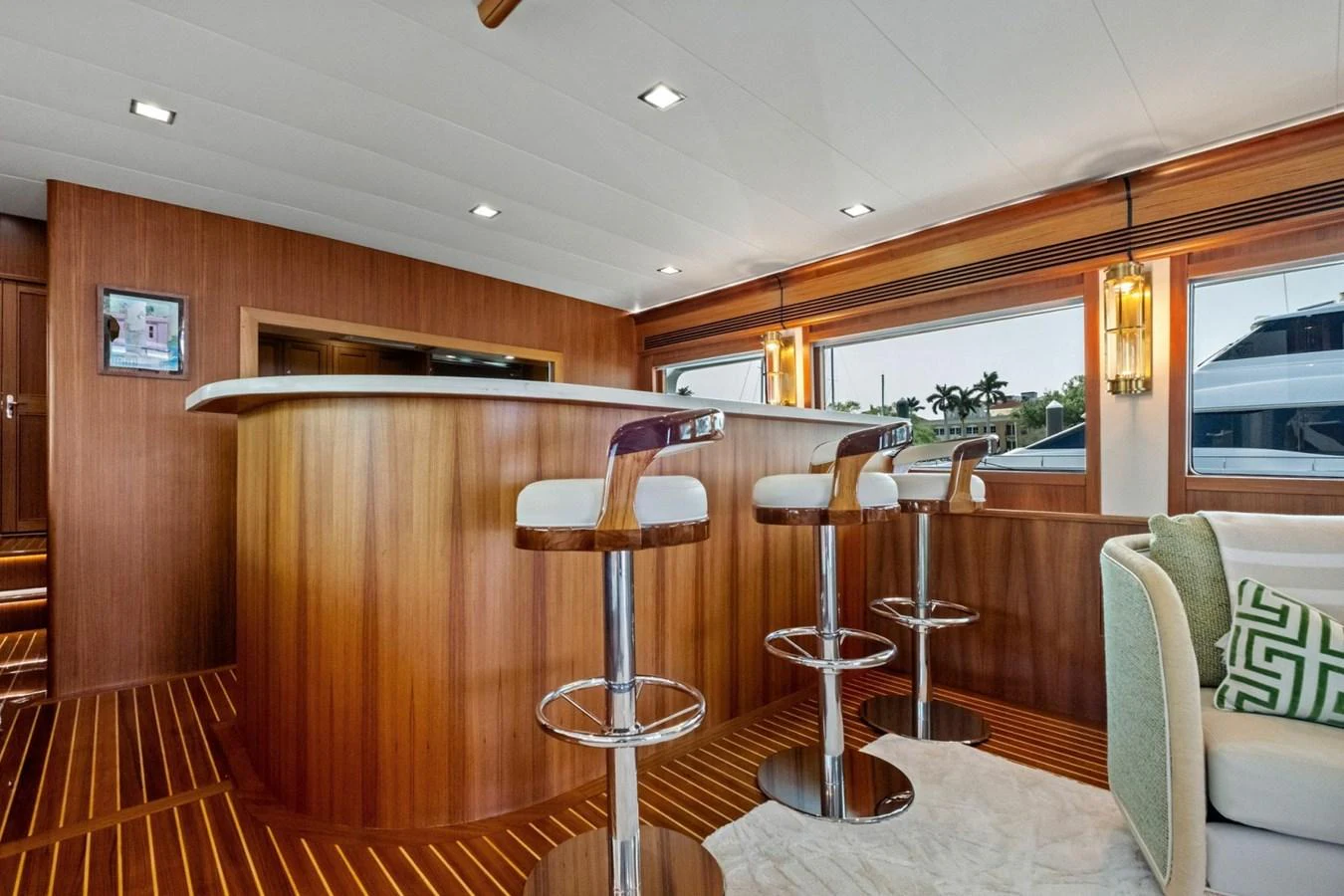 The yacht's interior features a stylish bar area with modern bar stools and warm wooden accents. aboard ARTEMIS II Yacht for Sale