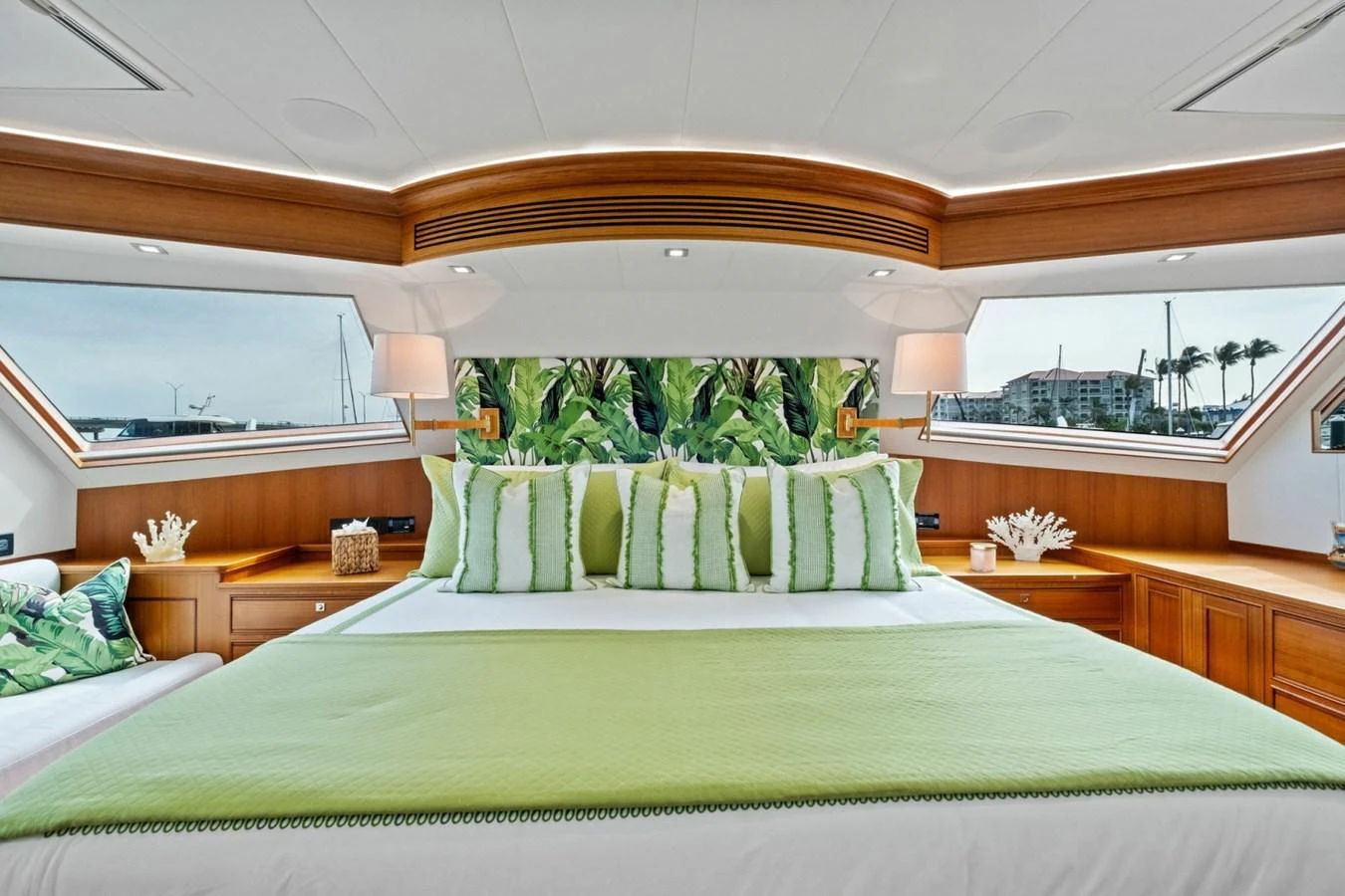 The master stateroom features a luxurious bed with vibrant green accents and large windows offering scenic views. aboard ARTEMIS II Yacht for Sale