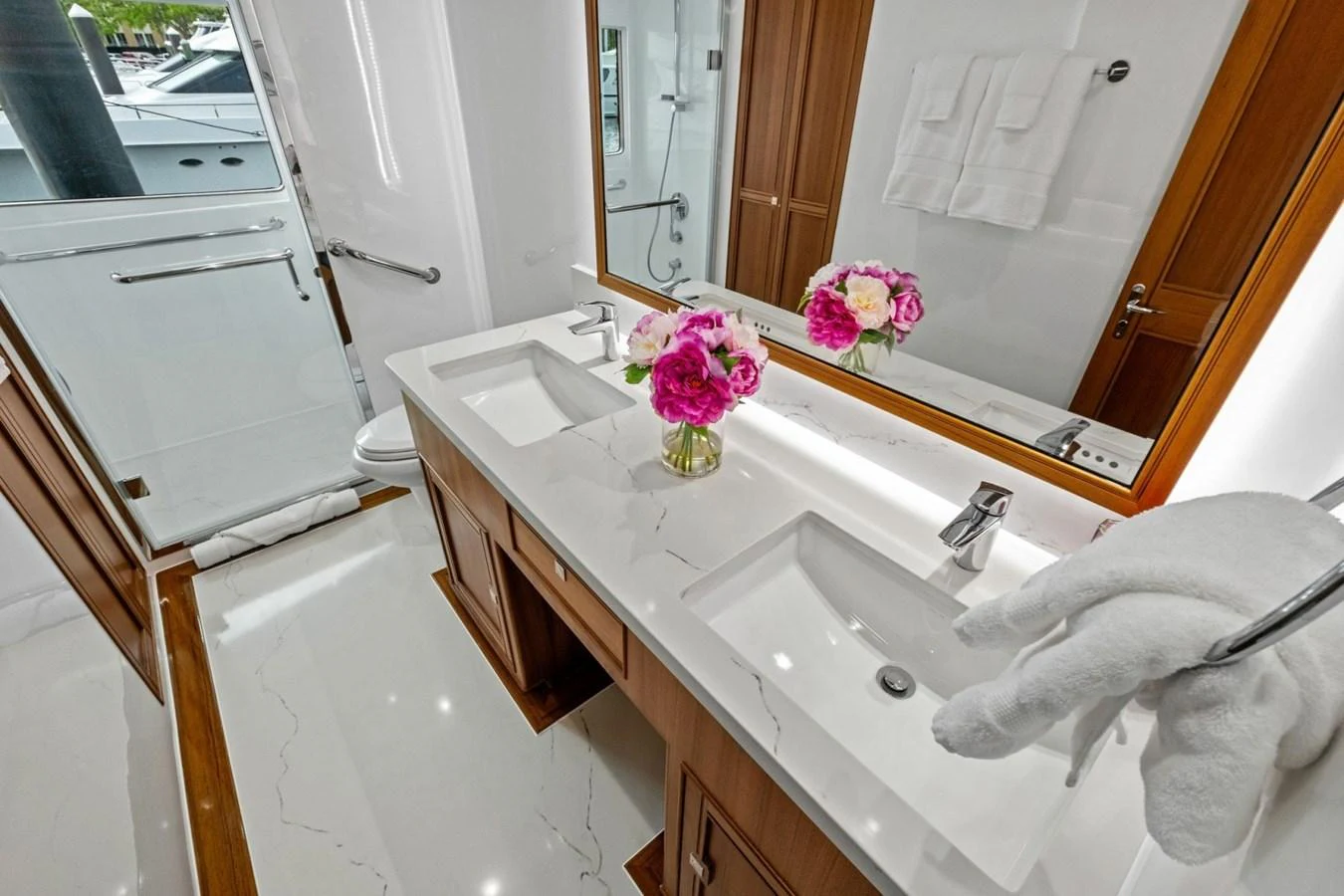 The yacht's bathroom features a double vanity with elegant fixtures and fresh flowers for a touch of luxury. aboard ARTEMIS II Yacht for Sale