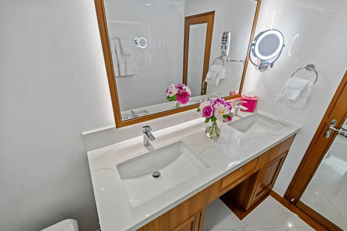 The bathroom features a double sink vanity with elegant fixtures and a fresh floral arrangement. aboard ARTEMIS II Yacht for Sale