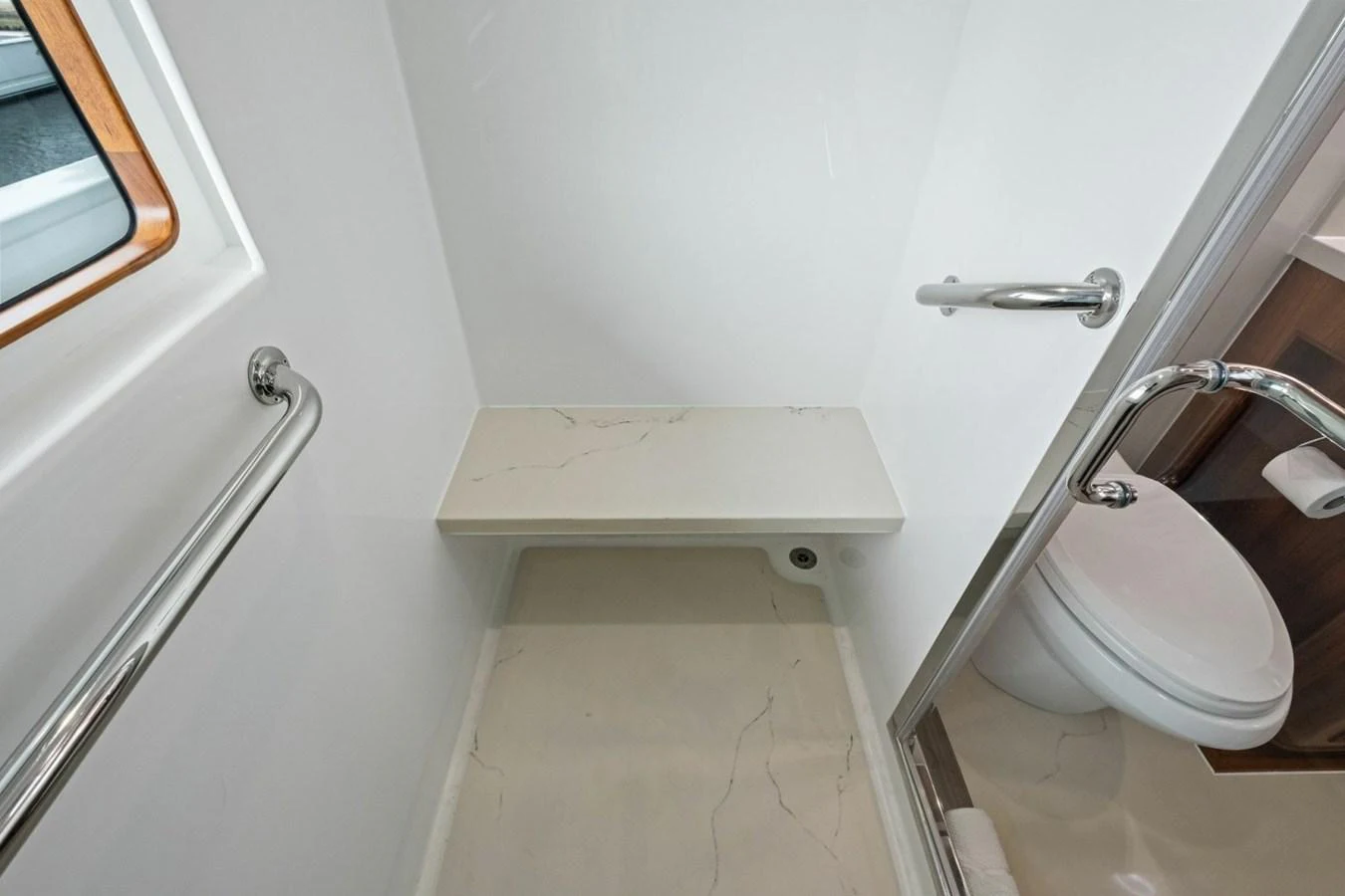 A compact and modern yacht bathroom featuring a sleek shower area and a toilet. aboard ARTEMIS II Yacht for Sale