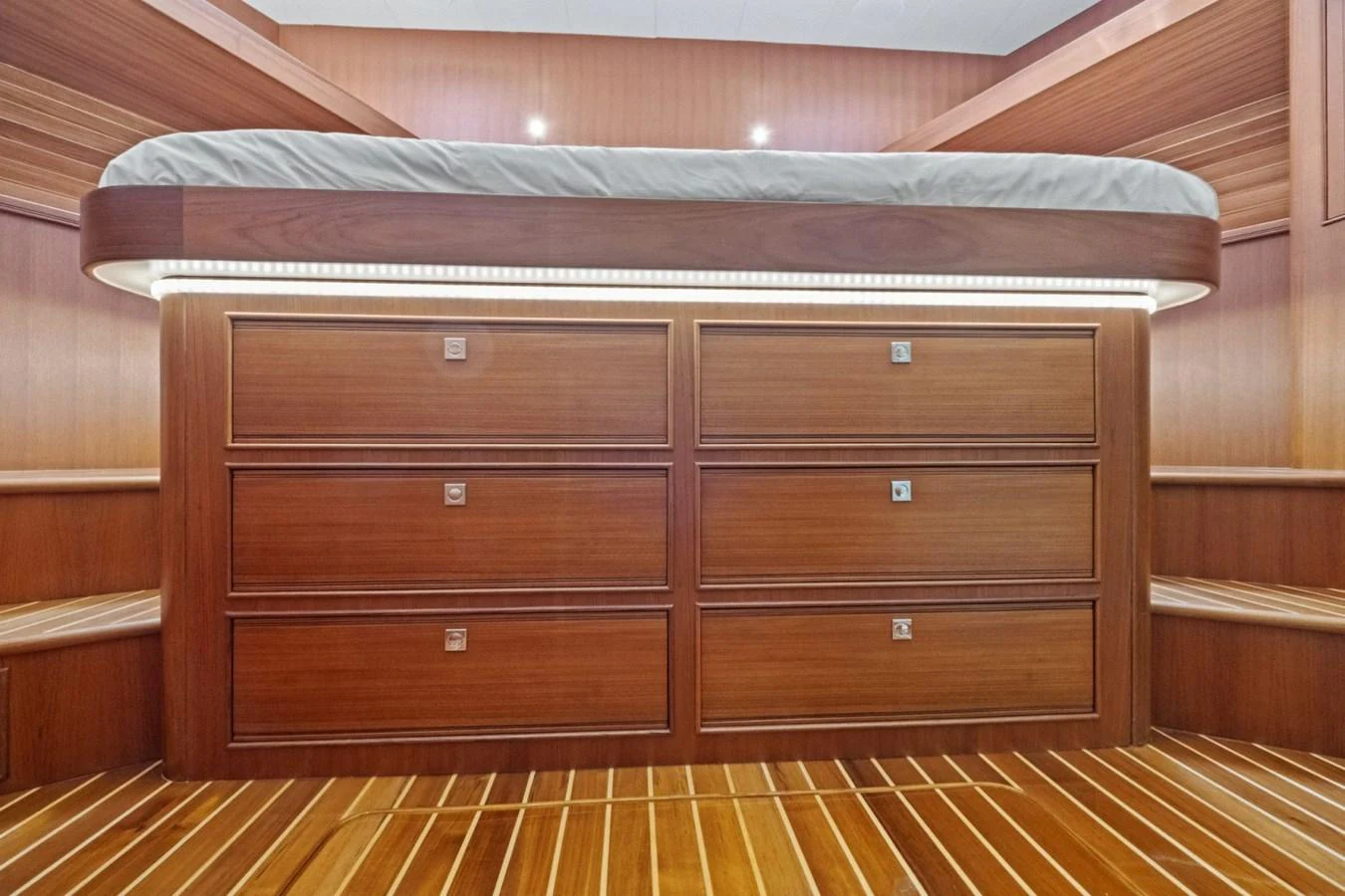 This image showcases a beautifully crafted wooden stateroom with ample drawer storage beneath a raised bed. aboard ARTEMIS II Yacht for Sale
