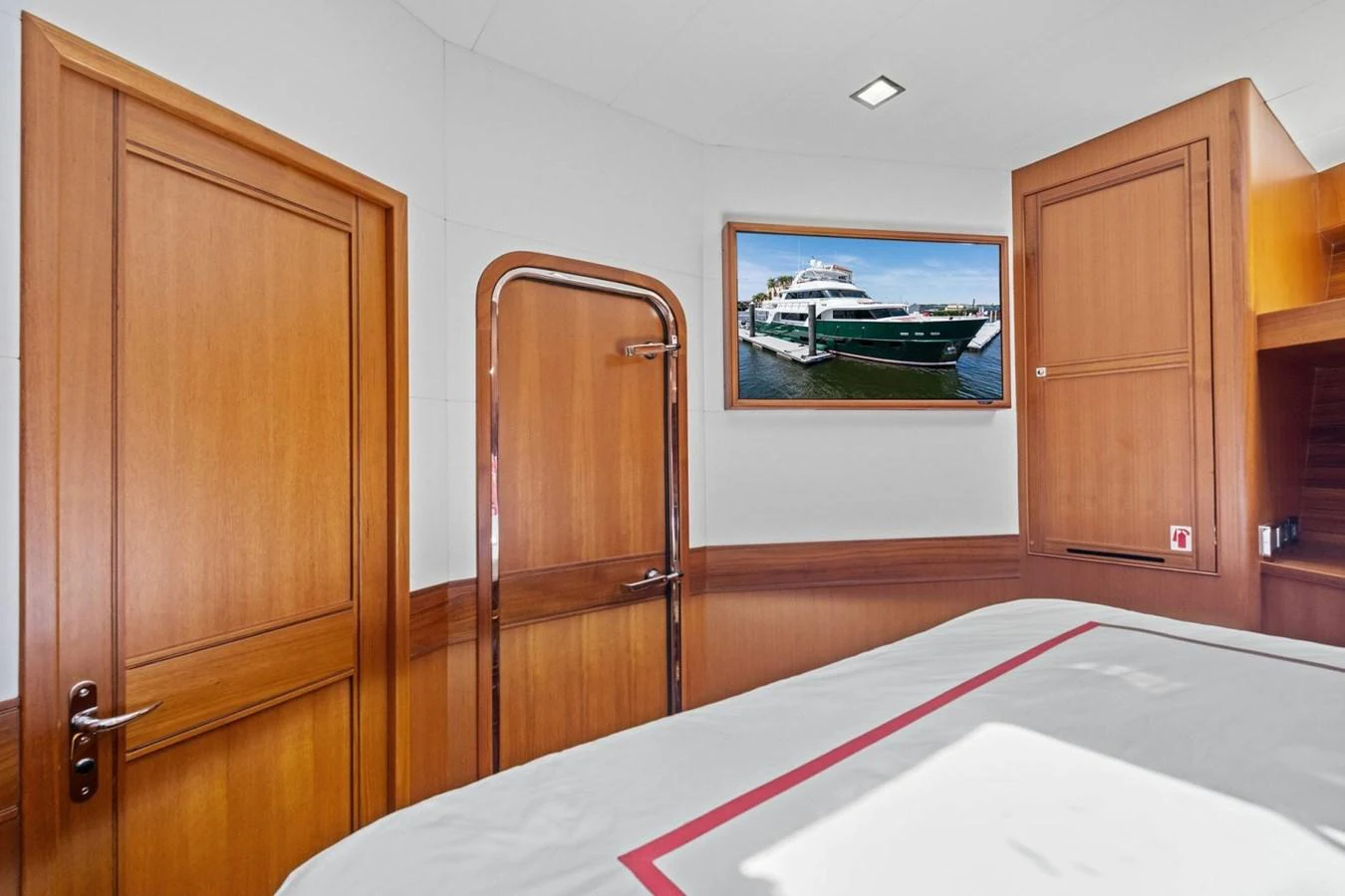 A cozy cabin with wooden finishes and a view of the yacht through a framed picture. aboard ARTEMIS II Yacht for Sale