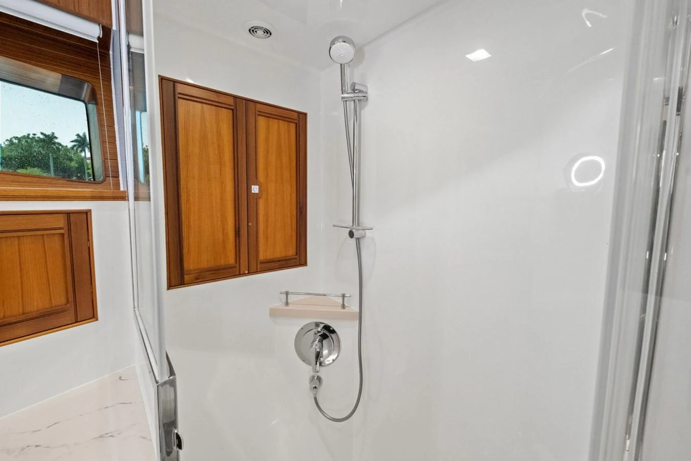 The yacht's bathroom features a sleek, modern shower area with wooden accents and ample natural light. aboard ARTEMIS II Yacht for Sale