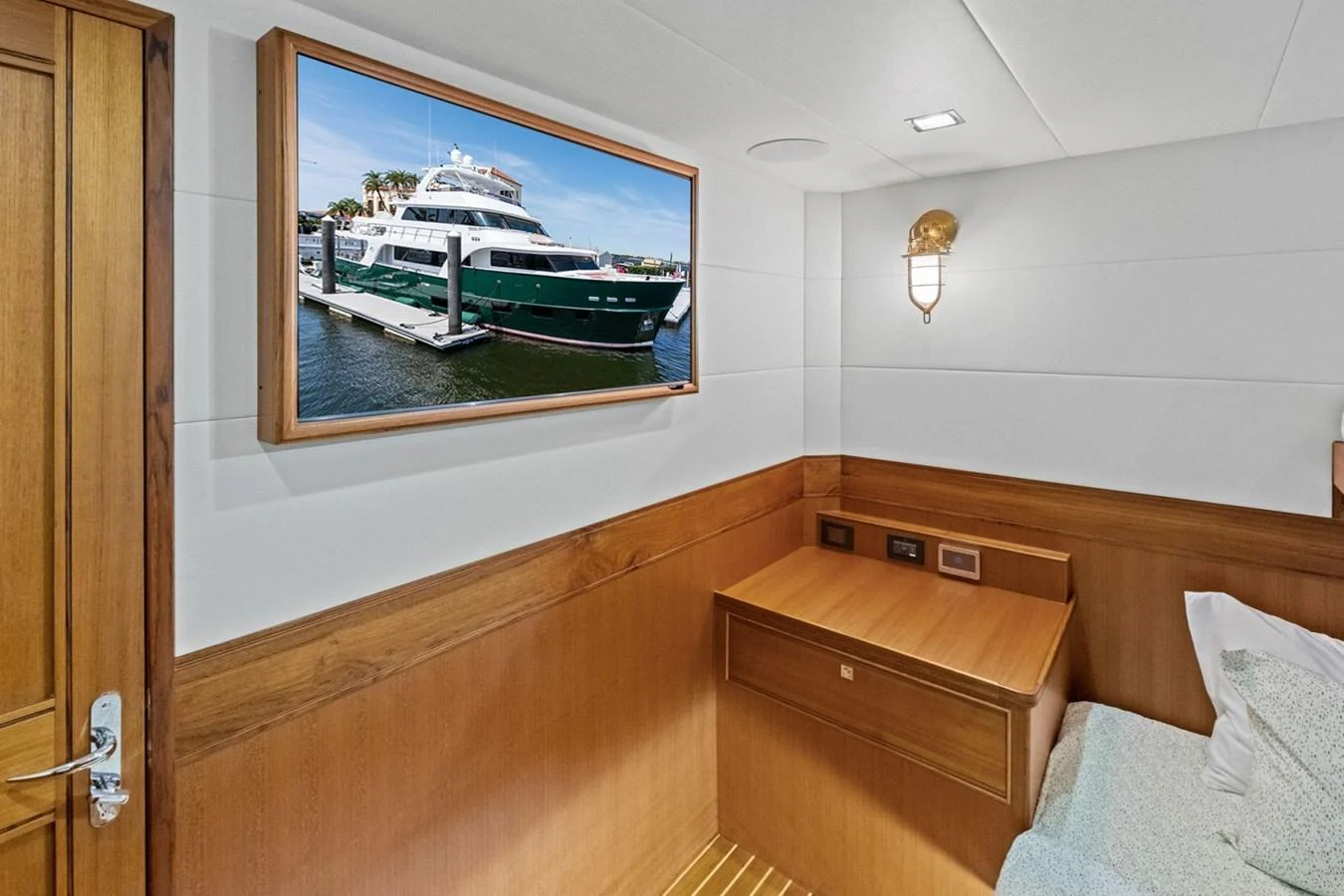 A cozy cabin with a wooden desk and a framed picture of a yacht on the wall. aboard ARTEMIS II Yacht for Sale