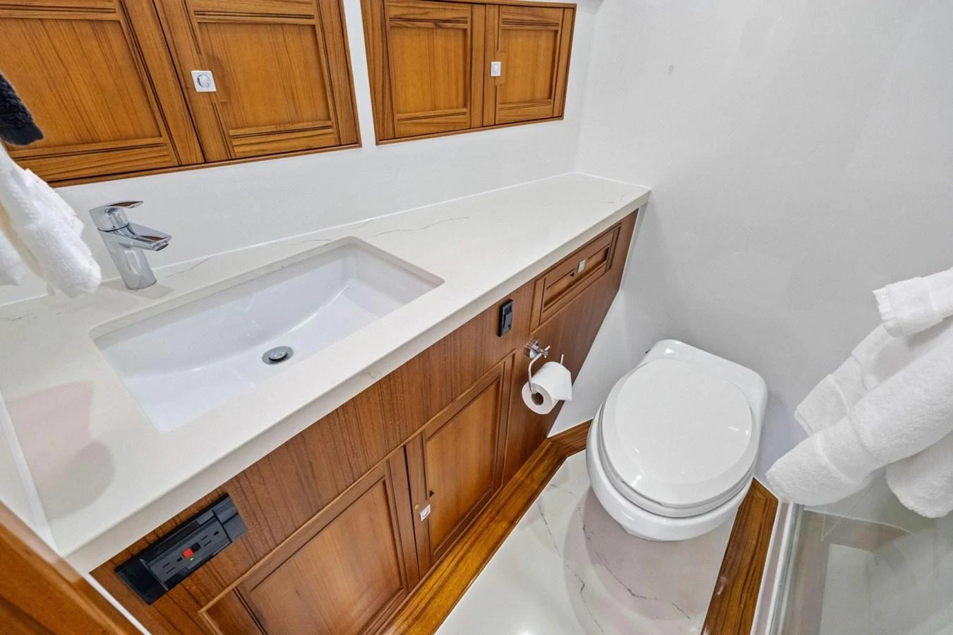 A well-appointed yacht bathroom featuring wood cabinetry and modern fixtures. aboard ARTEMIS II Yacht for Sale