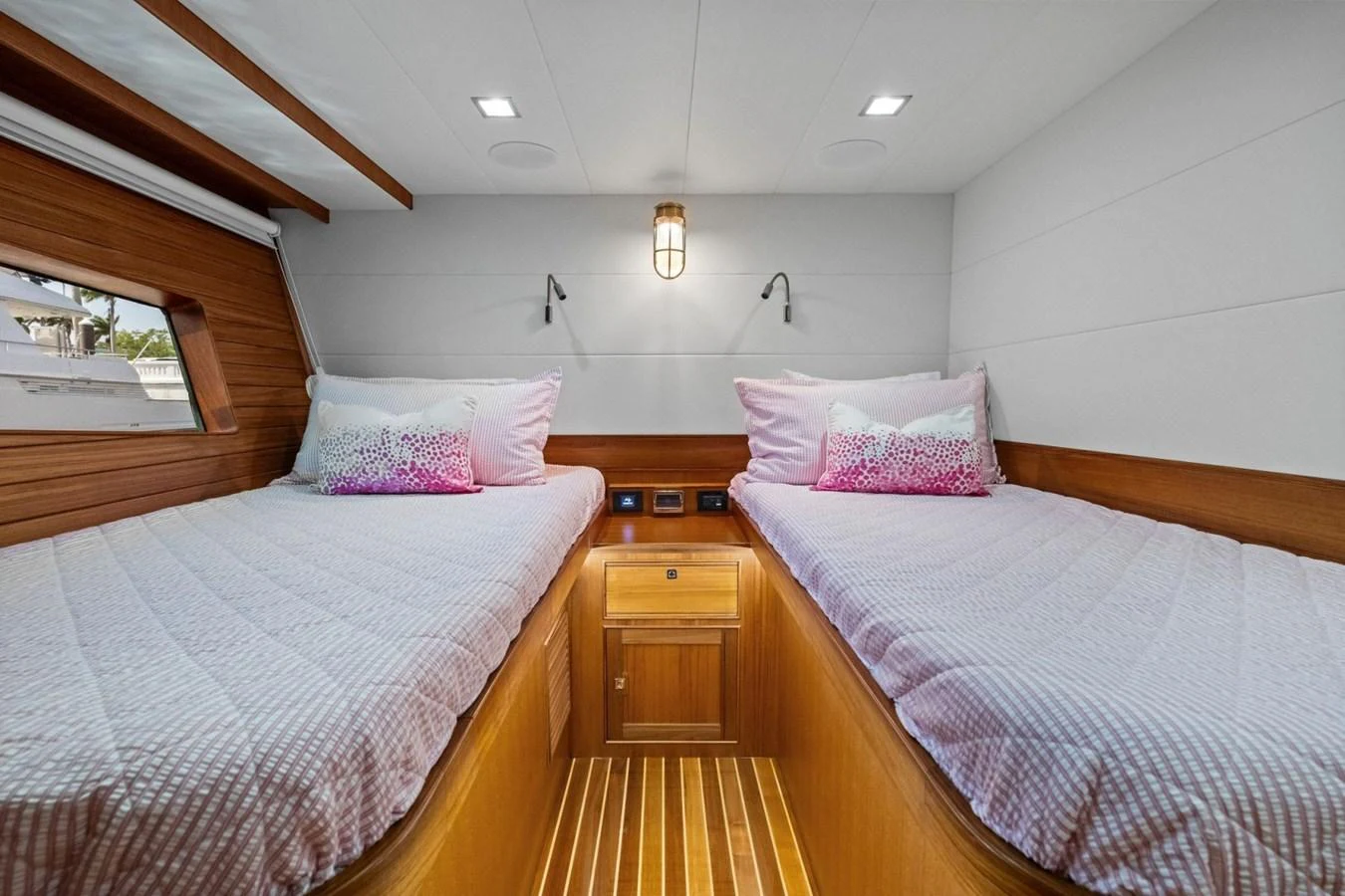The twin stateroom features two comfortable single beds with elegant bedding and warm wooden accents. aboard ARTEMIS II Yacht for Sale