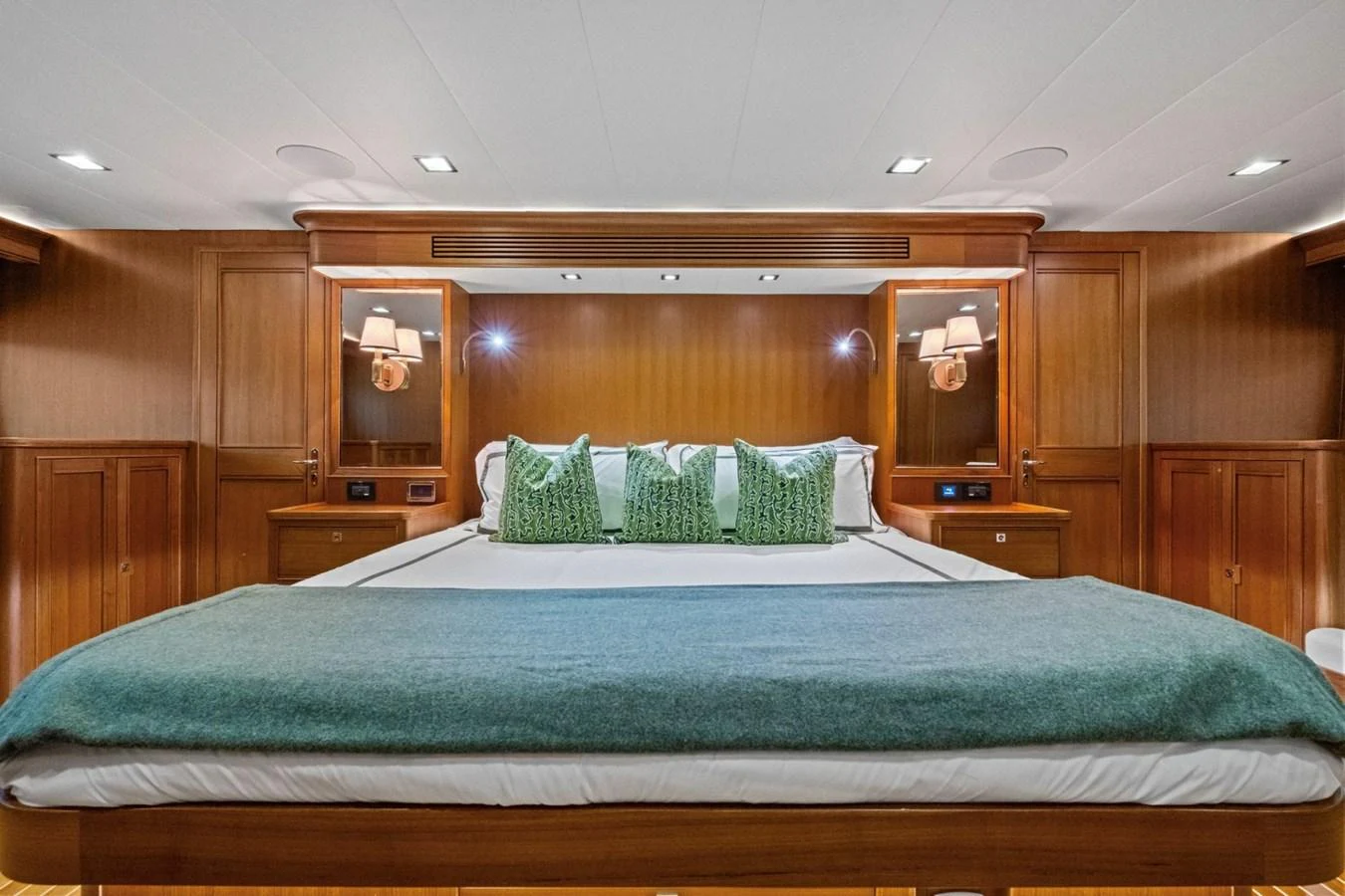 The master stateroom features a luxurious bed with elegant wooden cabinetry and soft lighting. aboard ARTEMIS II Yacht for Sale