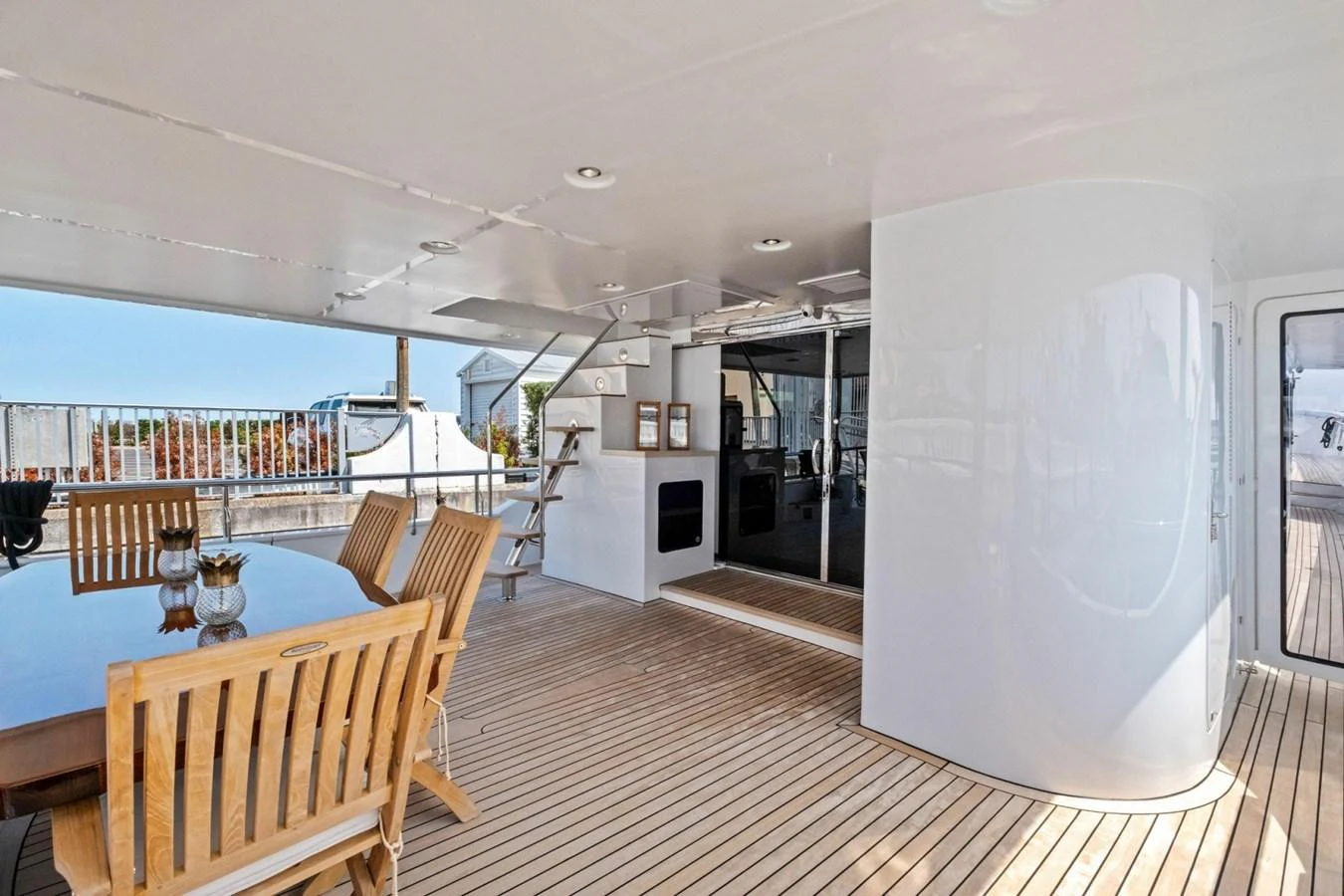 The aft deck features a spacious dining area with wooden chairs and a table, perfect for outdoor meals. aboard ARTEMIS II Yacht for Sale