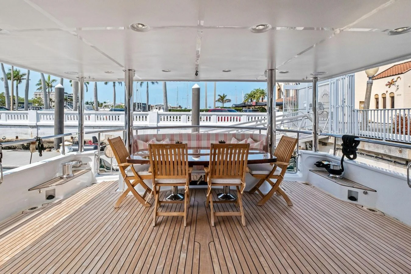 The aft deck features a spacious dining area with wooden chairs and a large table, perfect for alfresco meals. aboard ARTEMIS II Yacht for Sale