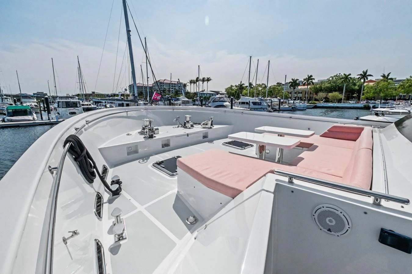The foredeck features a spacious lounging area with pink cushions and a small table, perfect for relaxing while docked at the marina. aboard ARTEMIS II Yacht for Sale