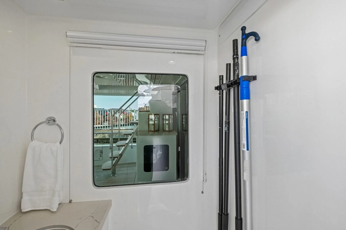A detailed view of a yacht's interior with a window looking out to the deck and some equipment stored inside. aboard ARTEMIS II Yacht for Sale