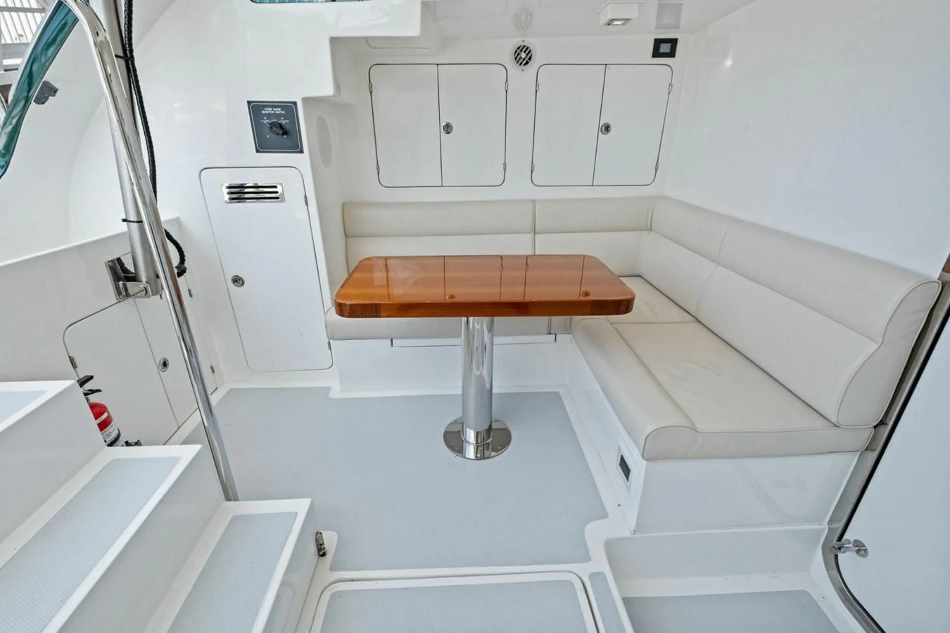 A cozy seating area with a wooden table and white cushioned benches. aboard ARTEMIS II Yacht for Sale