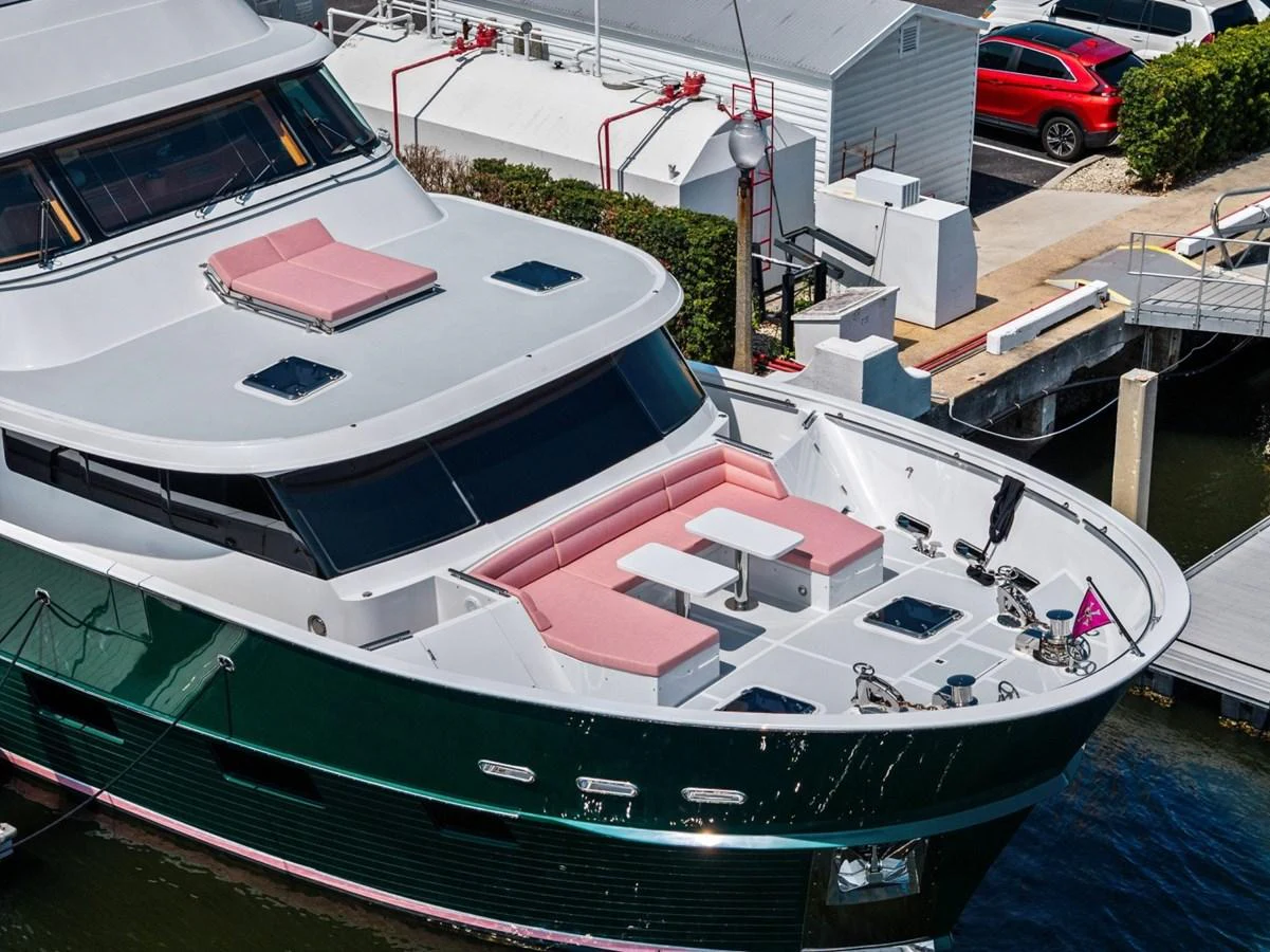 The yacht's foredeck features a spacious seating area with pink cushions and tables, perfect for relaxation and socializing. aboard ARTEMIS II Yacht for Sale