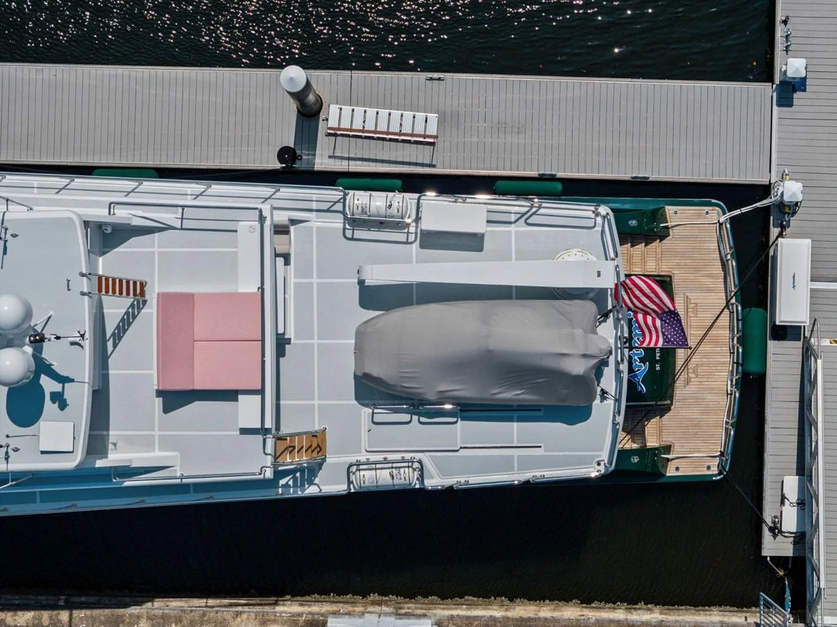 Aerial view of the yacht's aft deck, showcasing a covered tender and an American flag. aboard ARTEMIS II Yacht for Sale