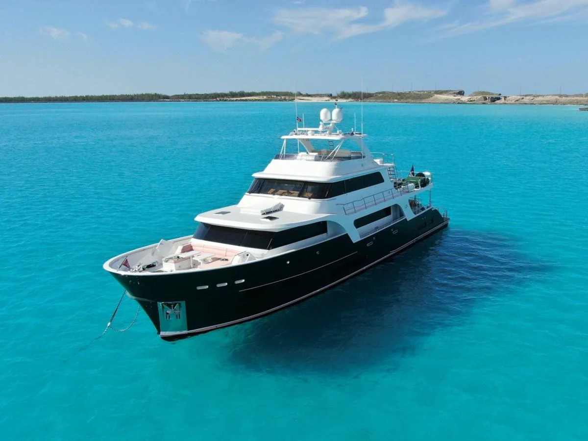 A luxurious yacht floats serenely on crystal-clear turquoise waters under a bright blue sky. aboard ARTEMIS II Yacht for Sale