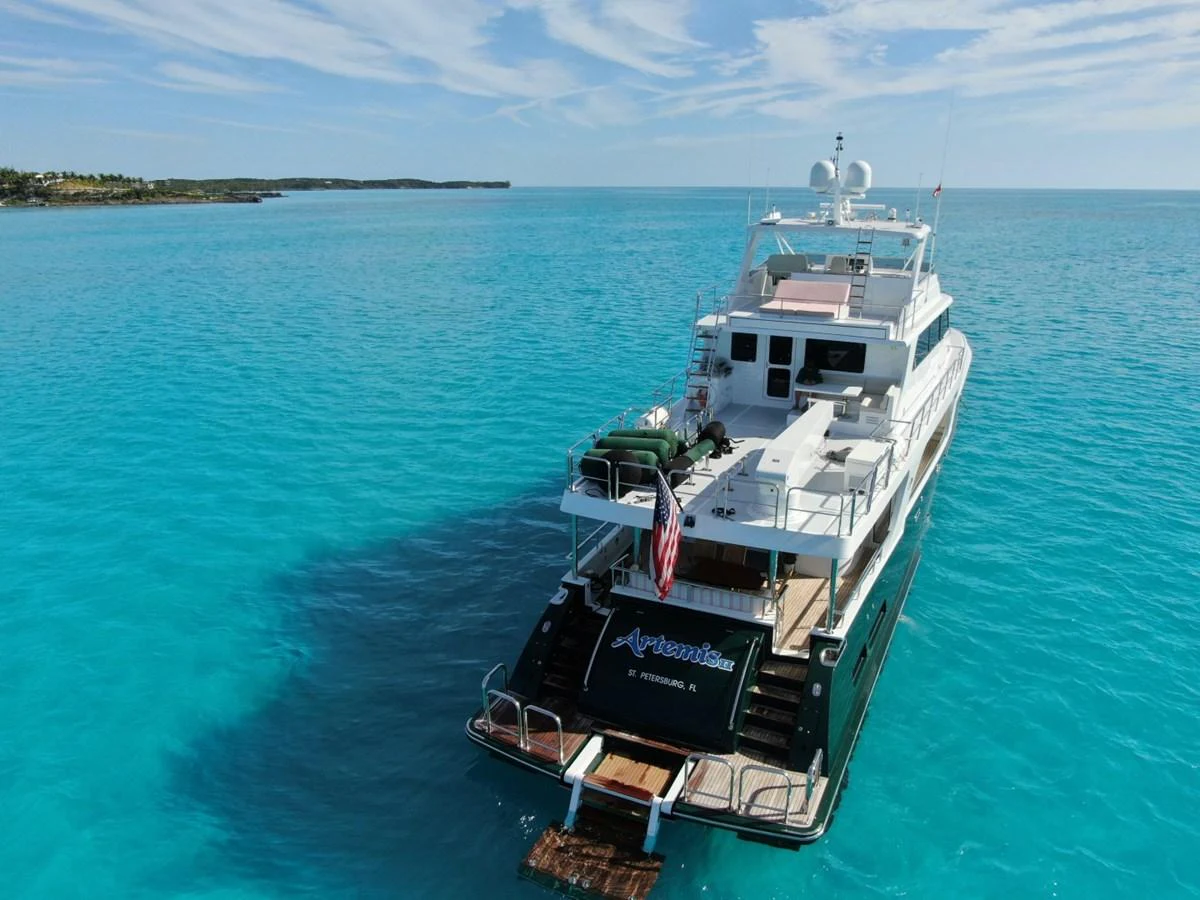 The yacht is anchored in crystal-clear waters, showcasing its spacious aft deck and luxurious amenities. aboard ARTEMIS II Yacht for Sale