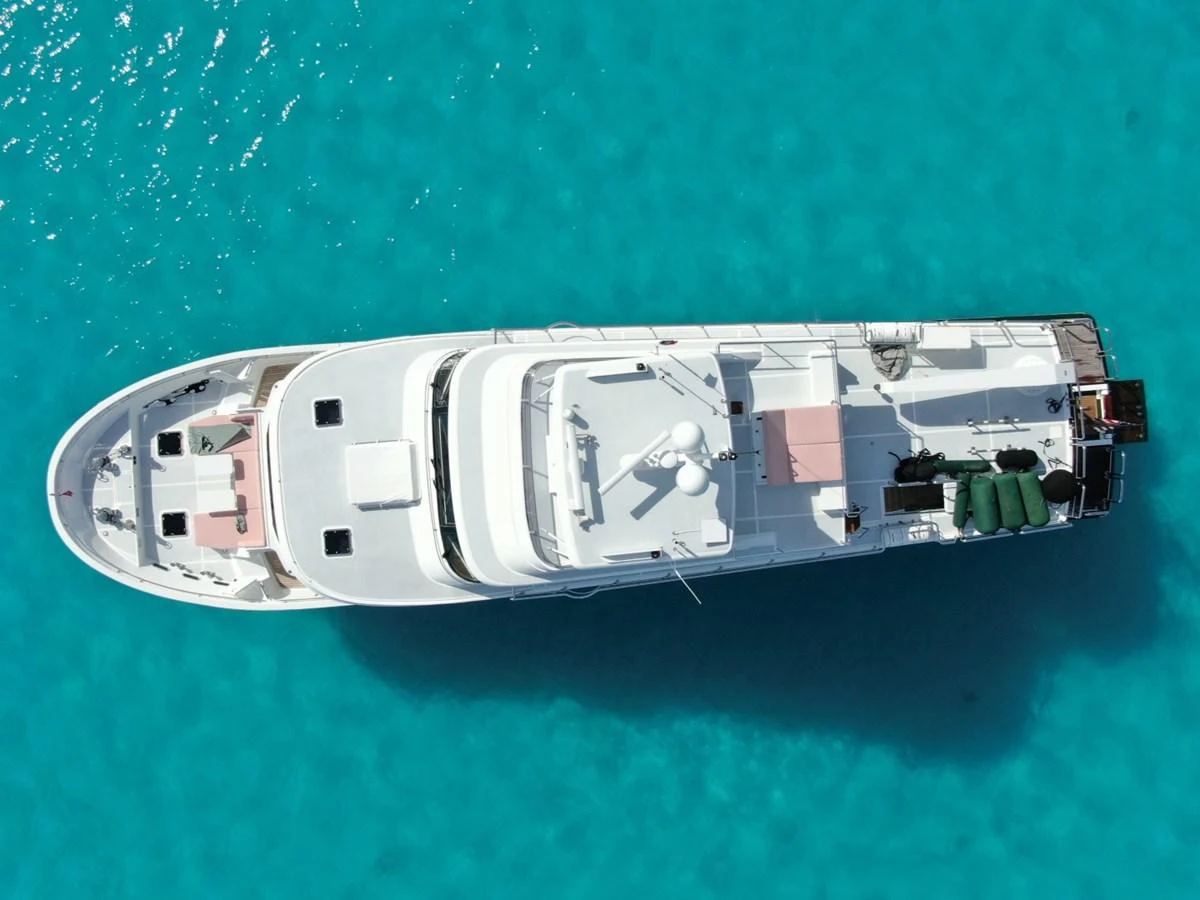 An aerial view of a luxurious yacht cruising in crystal-clear turquoise waters. aboard ARTEMIS II Yacht for Sale