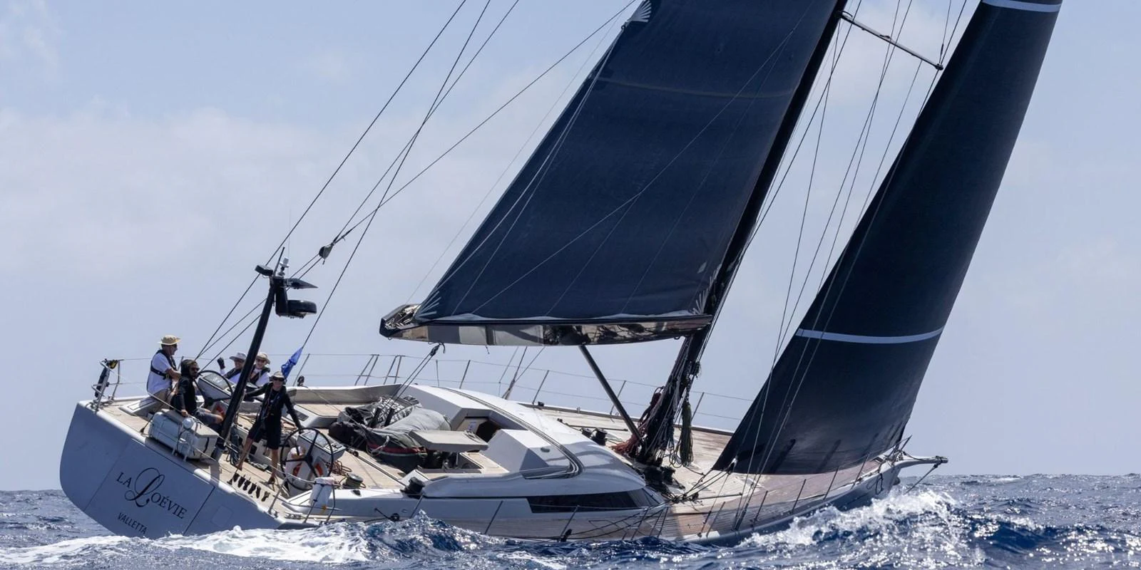 A sleek sailing yacht glides through the waves with its sails fully extended. aboard LA LOEVIE Yacht for Sale