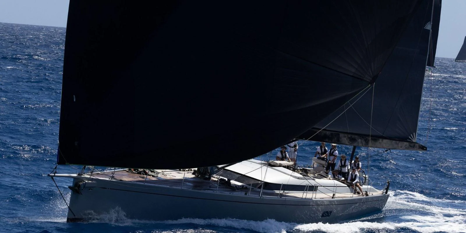 A sleek sailing yacht glides through the open sea with its sails fully extended. aboard LA LOEVIE Yacht for Sale