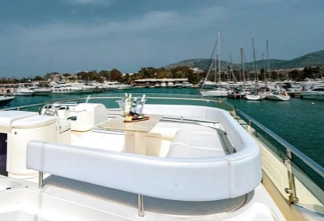The yacht's flybridge offers a serene seating area with a table, perfect for enjoying the view of the marina. aboard FERRETTI 810/78 Yacht for Sale