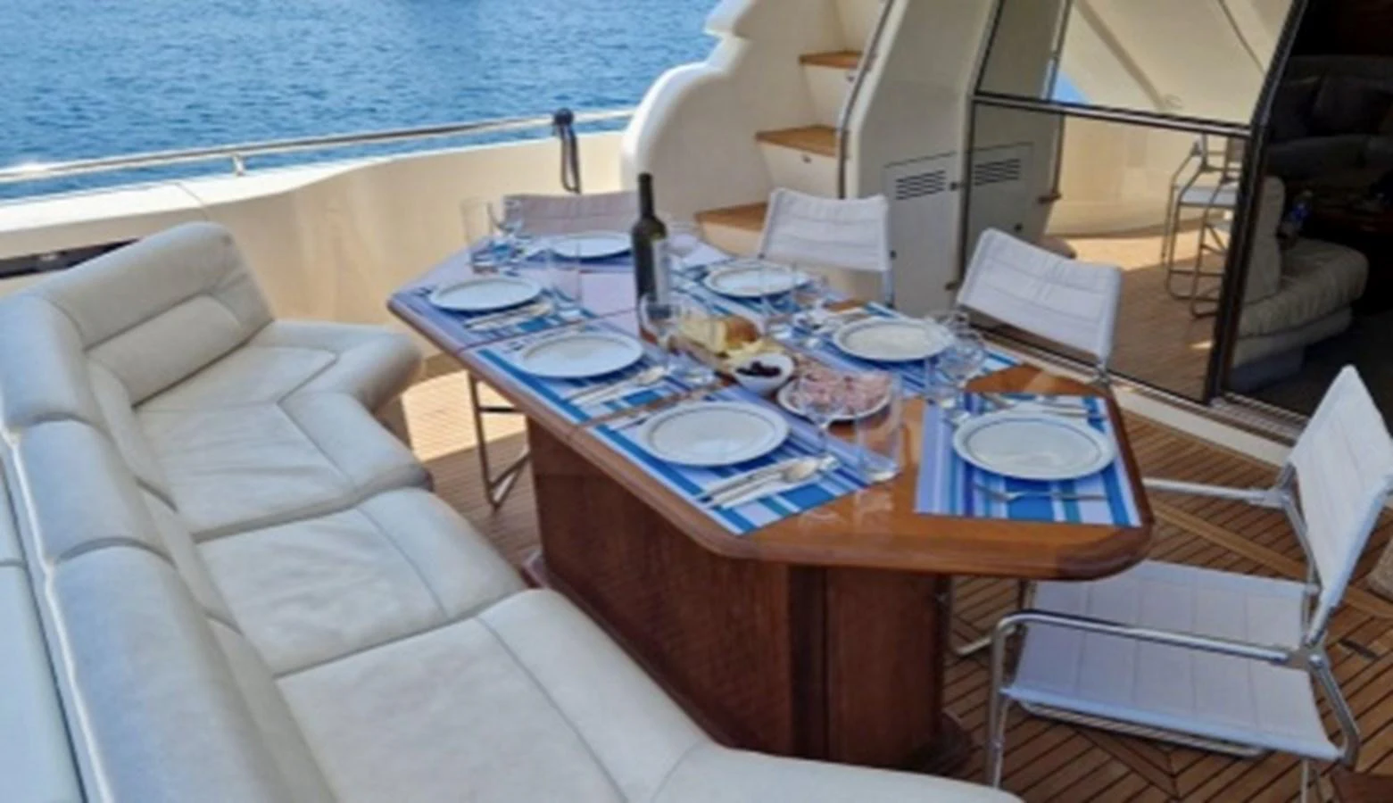 The aft deck features a beautifully set dining table with a view of the ocean. aboard FERRETTI 810/78 Yacht for Sale