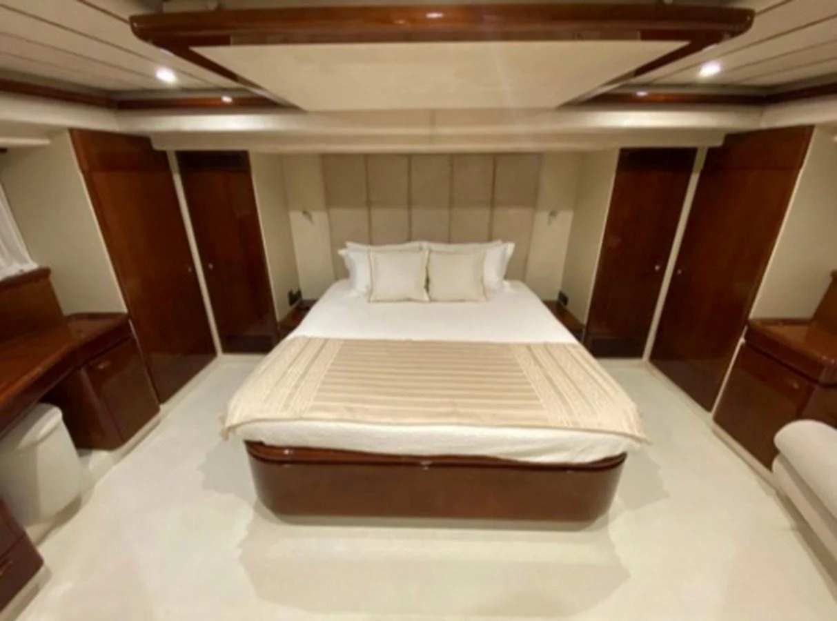 The master stateroom features a luxurious bed with elegant wood finishes and ample storage. aboard FERRETTI 810/78 Yacht for Sale