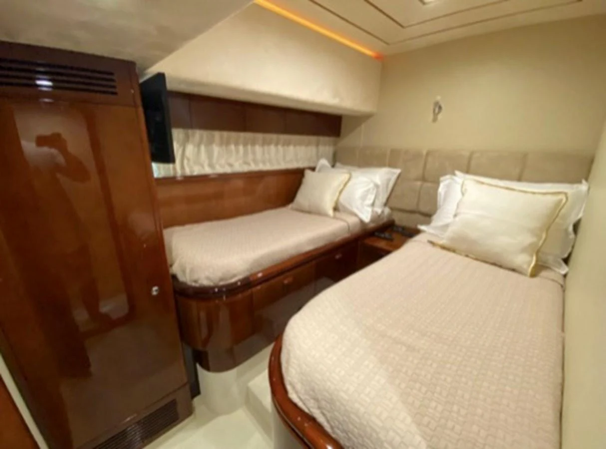 This cozy twin stateroom features two single beds with plush bedding and elegant wood finishes. aboard FERRETTI 810/78 Yacht for Sale