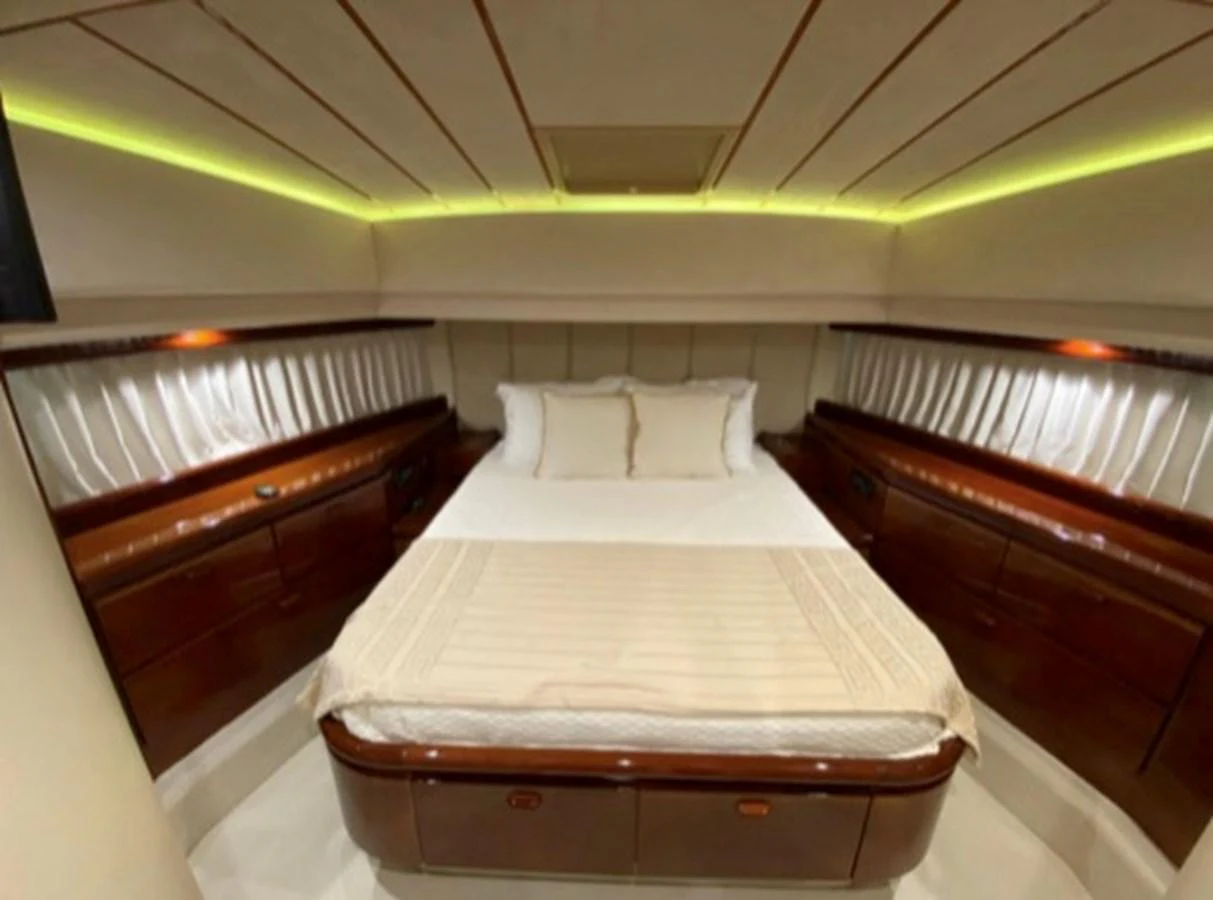 The stateroom features a luxurious bed with elegant wood finishes and ambient lighting. aboard FERRETTI 810/78 Yacht for Sale