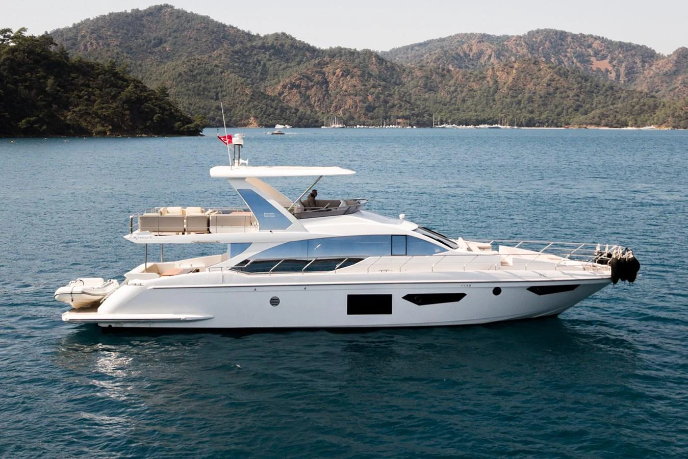 A sleek and modern yacht cruising on calm waters with a scenic mountainous backdrop. aboard AZ FLY 66 Yacht for Sale