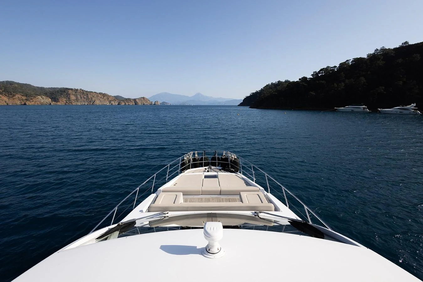 The yacht cruises through serene blue waters with a scenic coastal backdrop. aboard AZ FLY 66 Yacht for Sale
