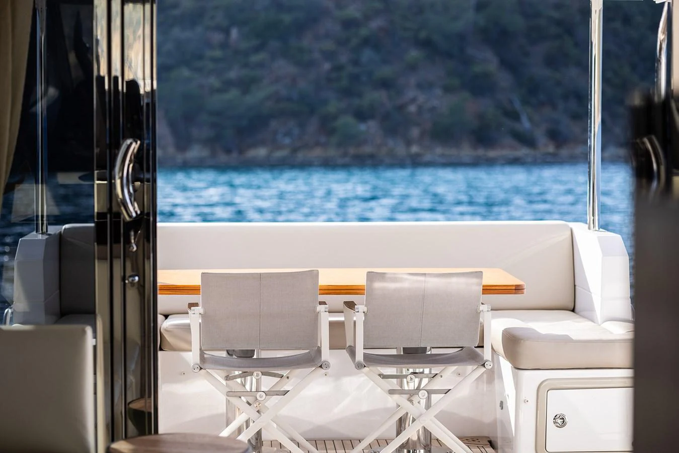 The aft deck features a cozy dining area with a stunning view of the water and surrounding landscape. aboard AZ FLY 66 Yacht for Sale