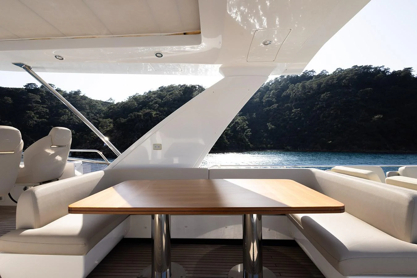The aft deck features a stylish dining area with a wooden table and cushioned seating, perfect for alfresco meals. aboard AZ FLY 66 Yacht for Sale