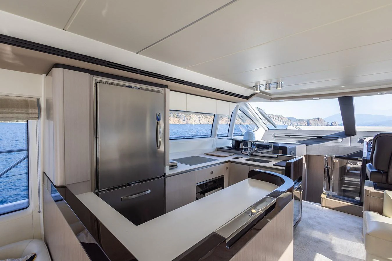 The yacht's galley features modern appliances and ample counter space with a scenic view through large windows. aboard AZ FLY 66 Yacht for Sale