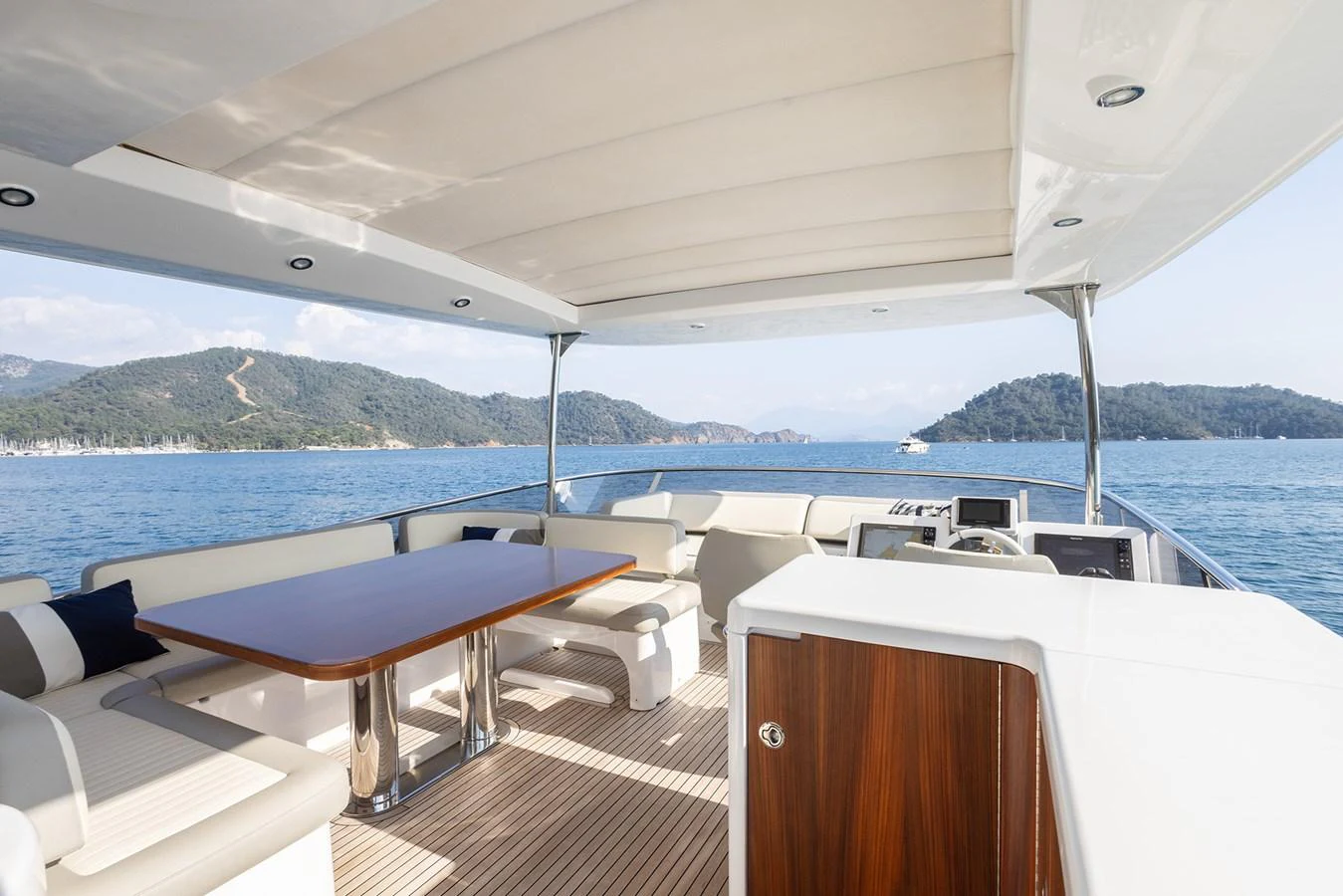 The aft deck offers a spacious and shaded area with comfortable seating and a dining table, perfect for enjoying the scenic views. aboard AZ MAGELLANO 66 Yacht for Sale