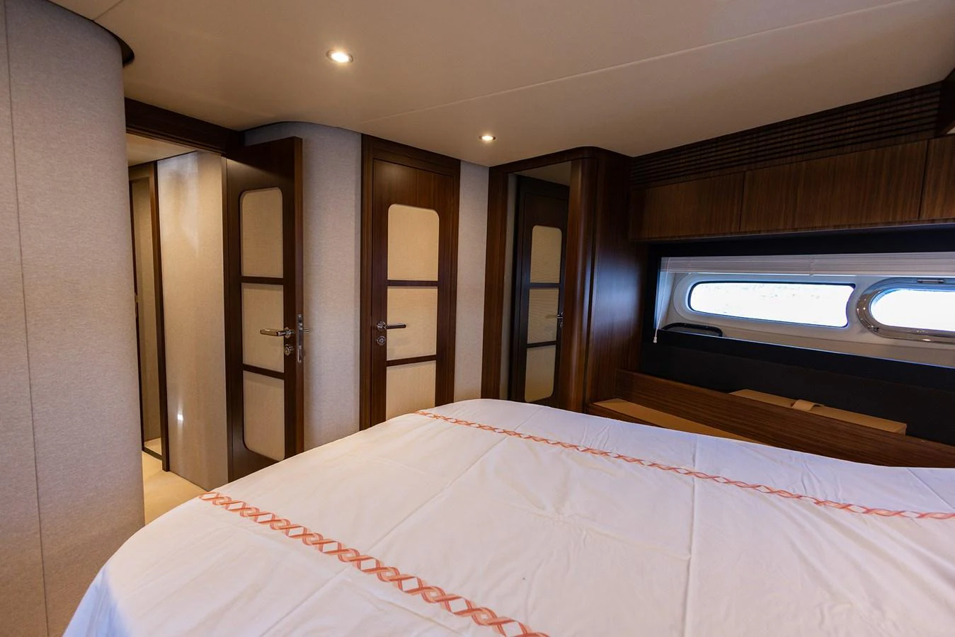 The stateroom features a cozy bed with elegant wood paneling and ample natural light from the window. aboard AZ MAGELLANO 66 Yacht for Sale
