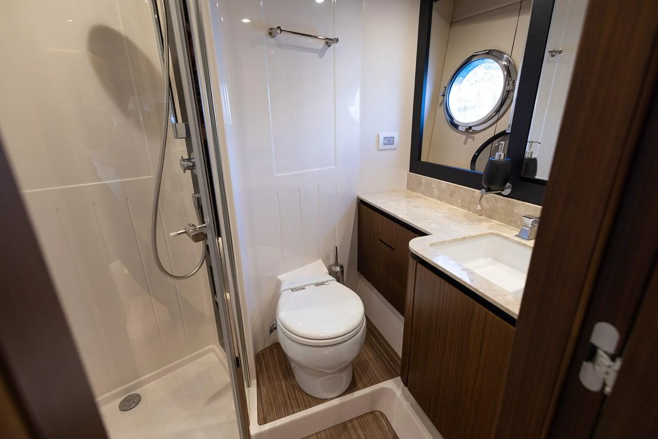 A well-appointed yacht bathroom featuring modern fixtures and a porthole window. aboard AZ MAGELLANO 66 Yacht for Sale